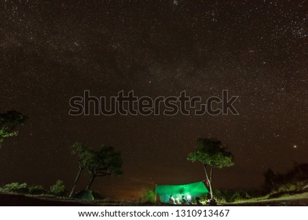 Camping fire under the amazing starry sky with a lot of shining stars in Thailand
