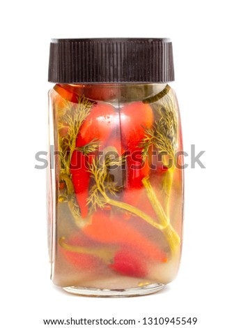 A glass jar with red marinated chilli peppers isolated on white background, studio photo.