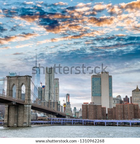 Brooklyn Bridge and Lower Manhattan skyline at dusk.