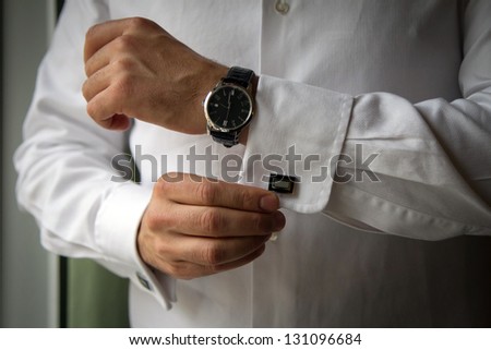 A man arranging his buttonholes. Royalty-Free Stock Photo #131096684