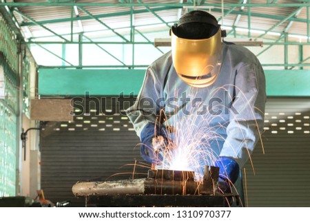 Professional welder with protective clothing and masks With the background in the industry. Welding gas in industrial plants.
