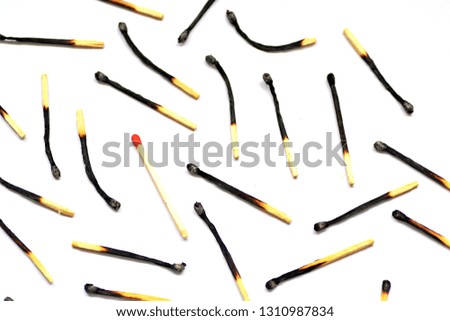 On a white, bright surface are many burned matches, only a single is intact and has a red head - concept for a competition from which only one person can emerge victorious