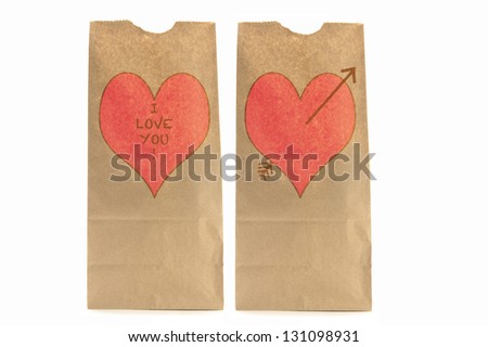 Two Brown paper lunch bags with heart and I love you written on it the other with Cupid's arrow