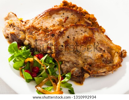 Image of  tasty cooked fried pork chop with  lentils, herbs and berries garnish  at plate 