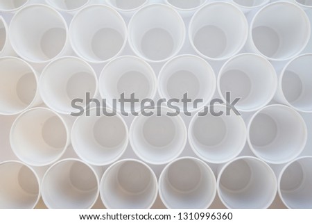 White single-use plastic cups top view as a background. Background pattern of group of plastic cups