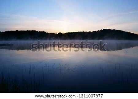 Beautiful view on the lake with fog at early morning just before sunrise.
