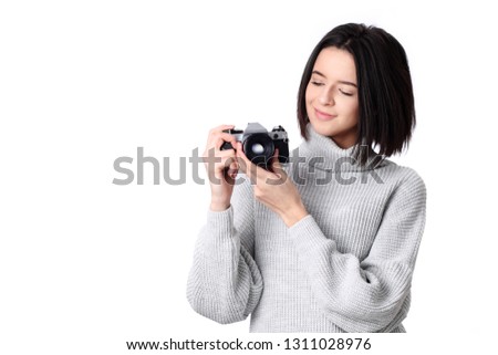 Pretty young stylish woman photographer posing outdoor with old vintage camera feels happy and smiling making photo selfi