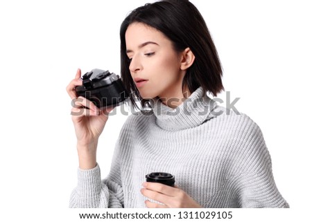 Woman takes images holding photographic camera, isolated on a white