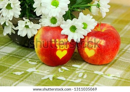 Two Red Apple with text I LOVE YOU with white flowers on green background. I love you apple. Apple for Valentine's Day