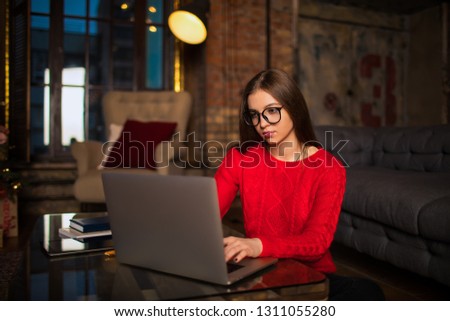 Young woman in glasses experienced graphic designer typing text on pc laptop computer, sitting in modern co-working space. Female fashion blogger publication article on site via notebook device 