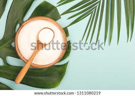 Collagen powder in bowl and measure spoon background. Extra protein intake. Natural beauty and health supplement. Minimal concept. Plant based collagen concept. Flatlay, top view. Copy space. Royalty-Free Stock Photo #1311080219