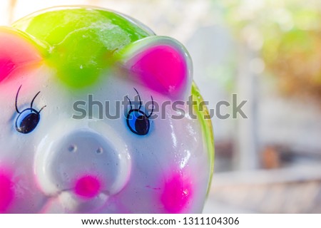 Saving money for a good future : Large piggy bank, green pig shape on Blurred bokeh nature background