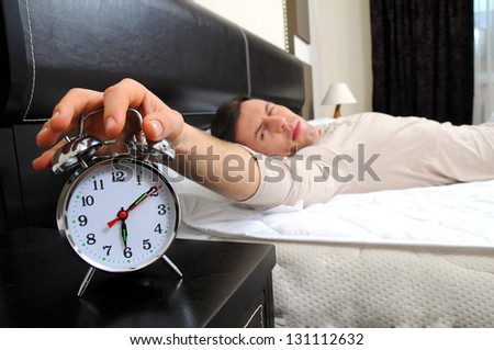 A man is sleeping with an alarm clock in front Royalty-Free Stock Photo #131112632