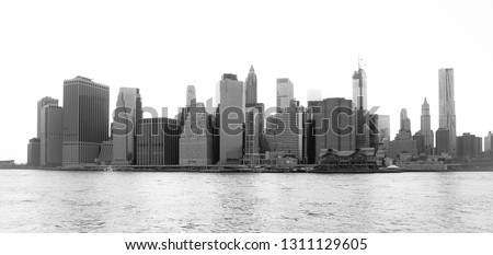 Panoramic view of New York Financial District and the Lower Manhattan at dawn viewed from the Brooklyn Bridge Park. High key black and white image.