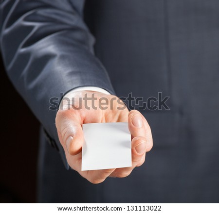 Closeup of young man's hand reaches out blank badge