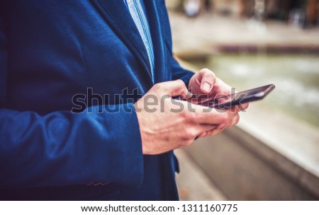 Businessman typing a message on mobile phone, close up photo. Business, education, lifestyle concept
