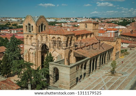 Santo Tome el Viejo Church facade in gothic style and large square amid rooftops landscape at Avila. It has the longest and imposing wall completely encircling this well-kept gothic town in Spain. Royalty-Free Stock Photo #1311179525
