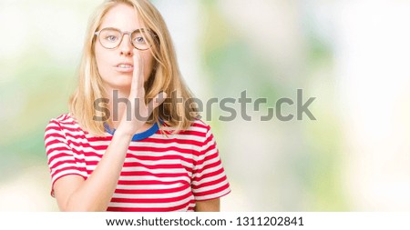 Beautiful young woman wearing glasses over isolated background hand on mouth telling secret rumor, whispering malicious talk conversation