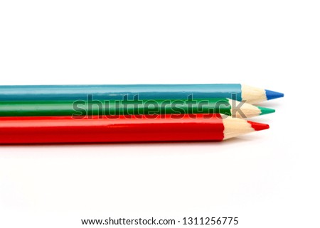 Three colored pencils. The colors red, green and blue. The concept of polygraphy and digital RGB color transfer.