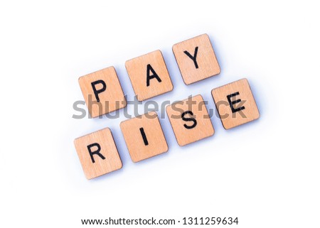 PAY RISE, spelt out with wooden letter tiles.