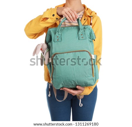 Woman holding maternity backpack with baby accessories on white background, closeup