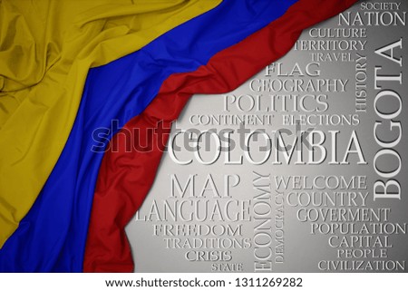 waving colorful national flag of colombia on a gray background with important words about country . concept