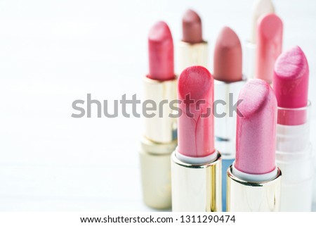 Set of colored pink lipsticks on white background. Women's cosmetics. Selective focus. Copy space