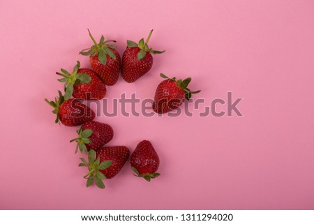 circle of strawberries teamwork on pink background