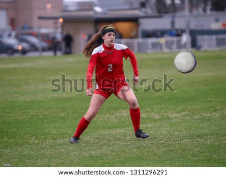 Young high school girl competing in a soccer game