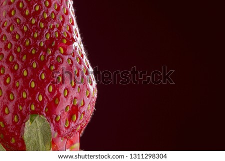 close up of a strawberry on dark red background