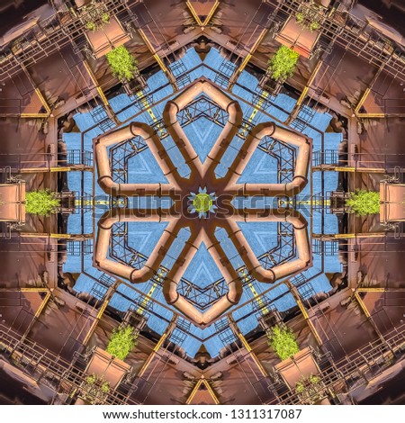 Metal flower made from an industrial photo. Geometric kaleidoscope pattern on mirrored axis of symmetry reflection. Colorful shapes as a wallpaper for advertising background or backdrop.