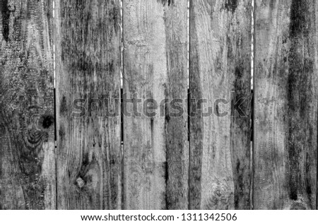 Weathered wooden fence in black and white. Abstract background and texture for design.