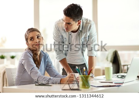 Young businesswoman feeling tired of listening her annoying boss who is scolding her in the office.  Royalty-Free Stock Photo #1311344612