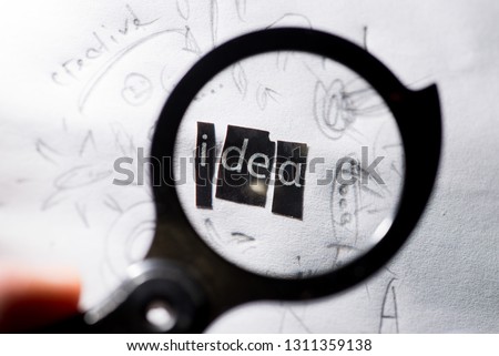search for ideas. Word idea composed of paper letters through a magnifying glass