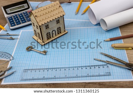 Wooden house model with key on millimeter paper