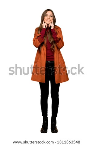 Full-length shot of Young woman with coat smiling with a happy and pleasant expression on isolated white background