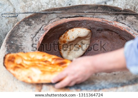 Testy tandoor bread placed in the oven Royalty-Free Stock Photo #1311364724