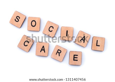 SOCIAL CARE, spelt with wooden letter tiles.