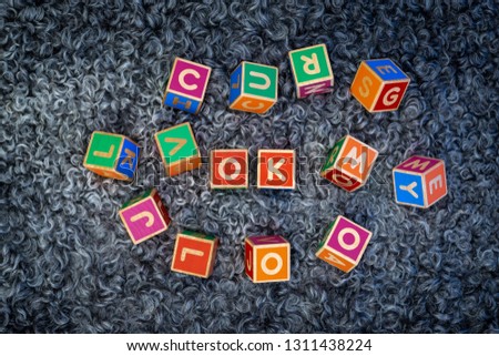 The word OK written with colorful wooden block letters on a sheepskin. The word is placed in the middle, with several cubes randomly placed around it.