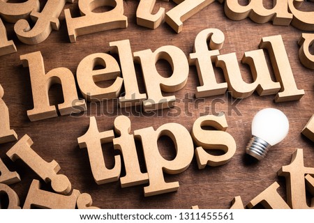 HELPFUL TIPS in scattered wood letters on the table with glowing light bulb