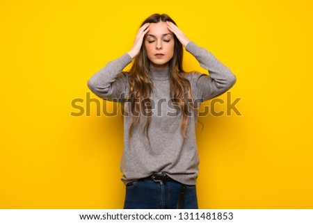 Young woman over yellow wall unhappy and frustrated with something