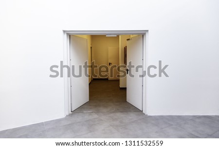 White door on a new white room, detail of the interior of a new building, modern architecture and