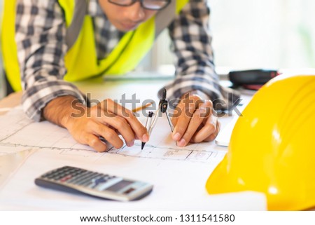 Architect working on blueprint.engineer inspective in workplace - architectural project, blueprints,ruler,calculator,laptop and divider compass. Construction concept. Engineering tools,selective focus