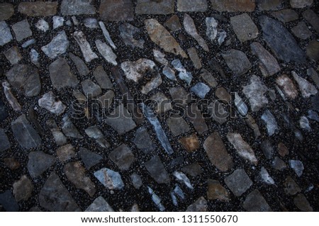 Stone pavement texture, granite cobblestoned pavement background, cobbled stone road regular shapes, abstract background of old cobblestone pavement close-up