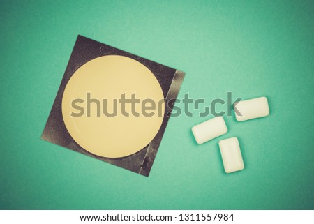 Nicotine patch and chewin gum used for smoking cessation isolated on green background Royalty-Free Stock Photo #1311557984