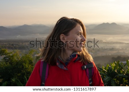 Hipster young girl with backpack  hiking in the mountains and enjoying a beautiful nature. Travel concept