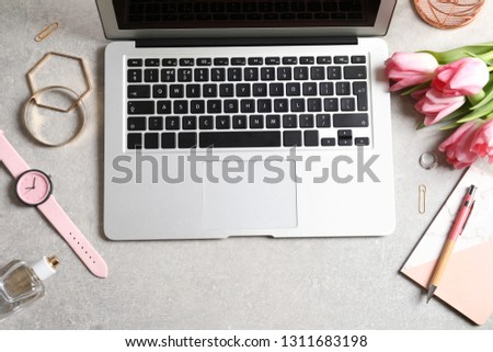 Flat lay composition with laptop and flowers on table. Woman's workplace