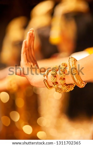 Graceful hands of Khmer Apsara dancers in traditional costume performs classical Khmer dance, beautiful golden glittering on backgrounds, selective focus. Public show in Phnom Penh, Cambodia.