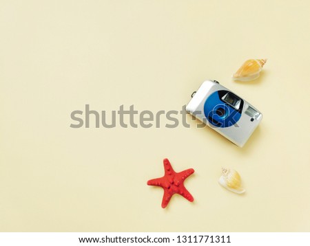 Flat lay composition creative summer travel photography. Retro camera, red starfish and seashells on a beach sand. Mockup for banner design