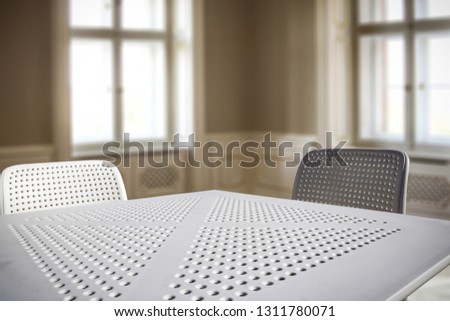 White table with two chairs and blurred background of window. Free space for your decoration. 
